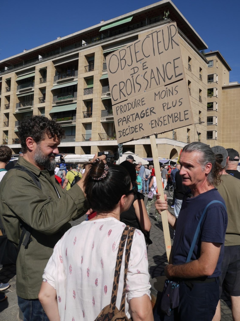 Manifestation du 18/09/25 à Marseille. Un manifestant tient une pancarte "Objecteur de croissance : produire moins, partager plus, décider ensemble" © Gaëlle Cloarec